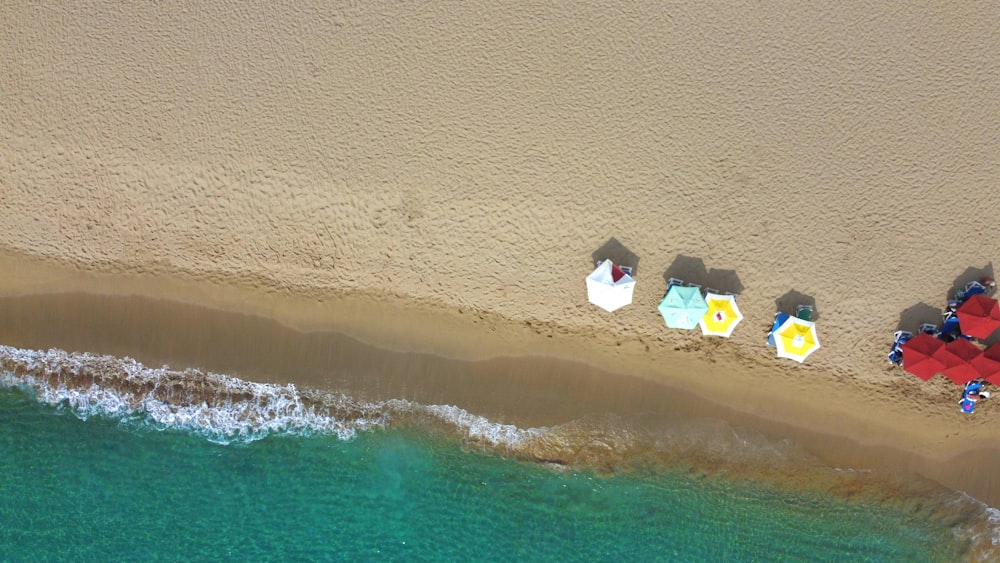 an aerial view of a beach with umbrellas