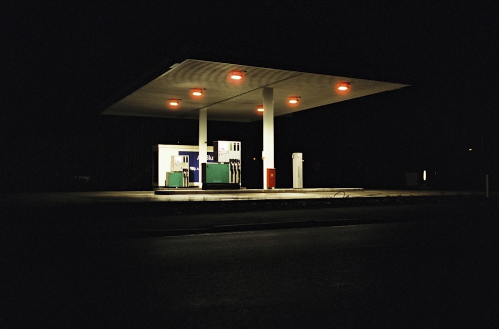 a gas station lit up at night with lights on
