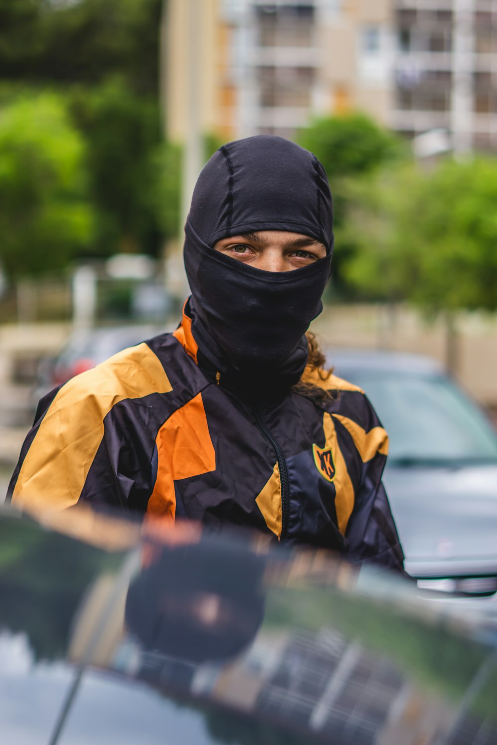 a person wearing a black and yellow jacket and a black mask