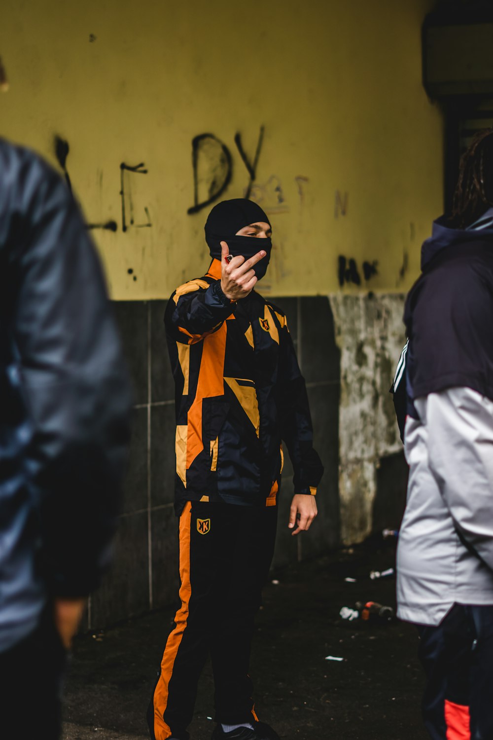 a man in a yellow and black suit standing in front of a wall