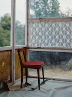 Rustic wooden chair with visible scratches and a cozy cushion.