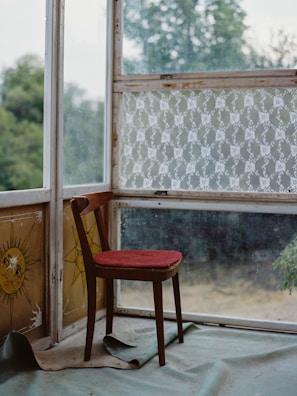 Rustic wooden chair with visible scratches and a cozy cushion.