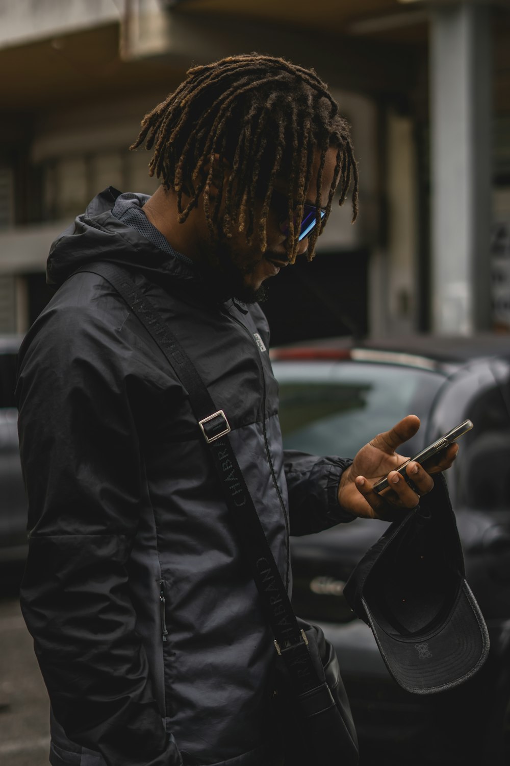 a man with dreadlocks looking at his cell phone