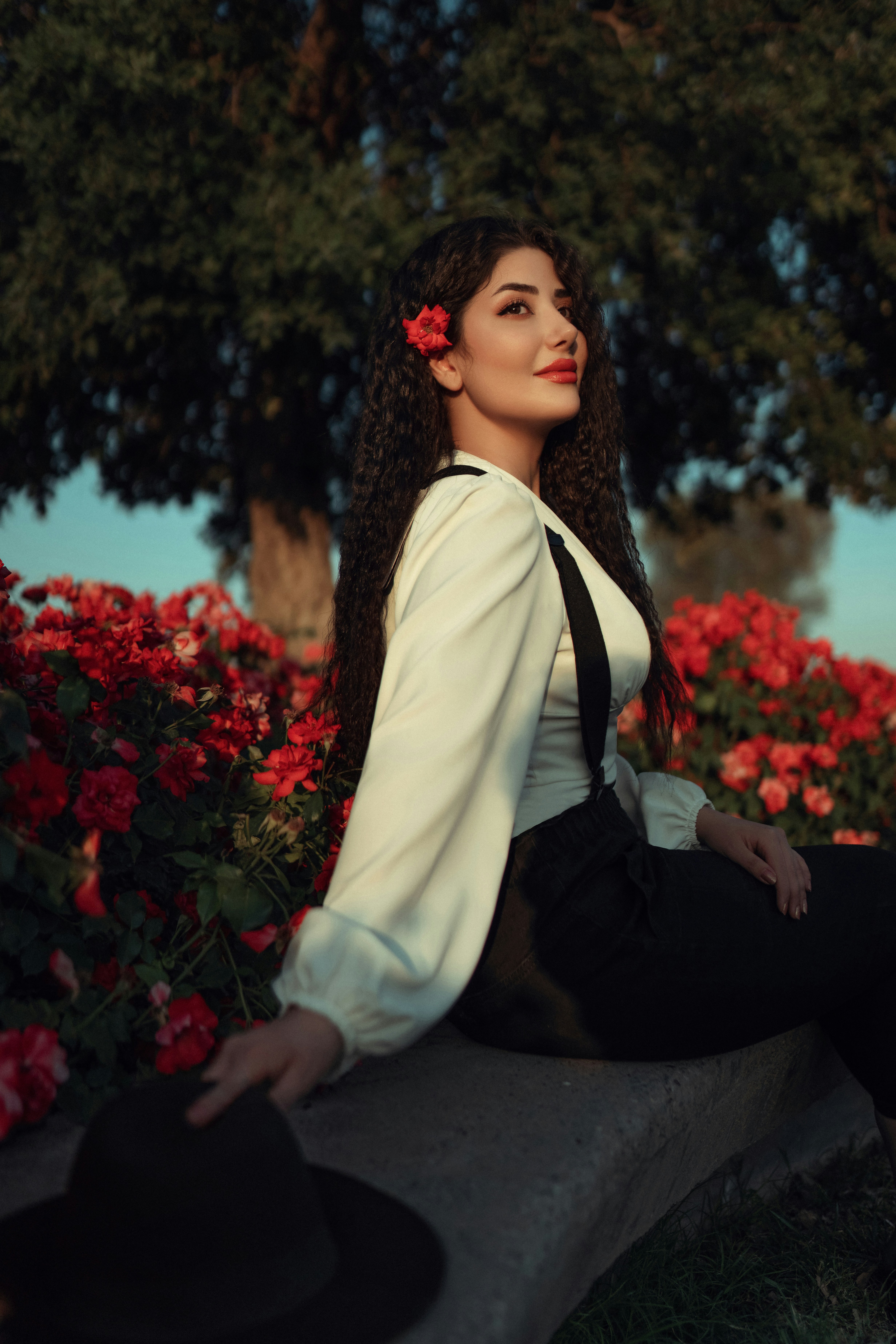 꽃밭의 돌 벤치에 앉아 있는 여자