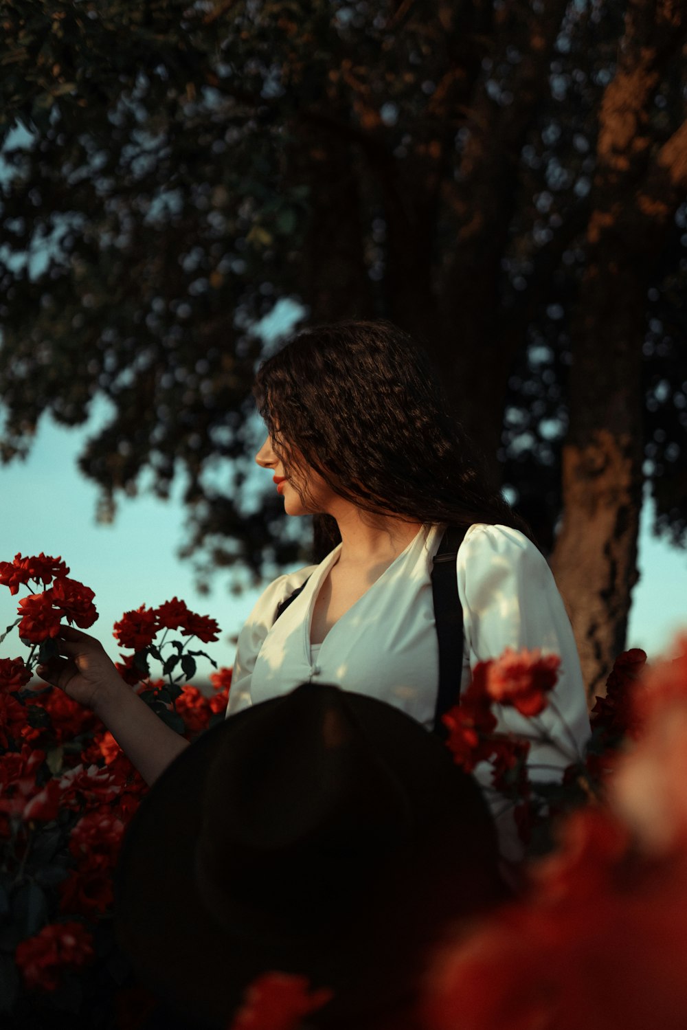 a woman standing in a field of red flowers