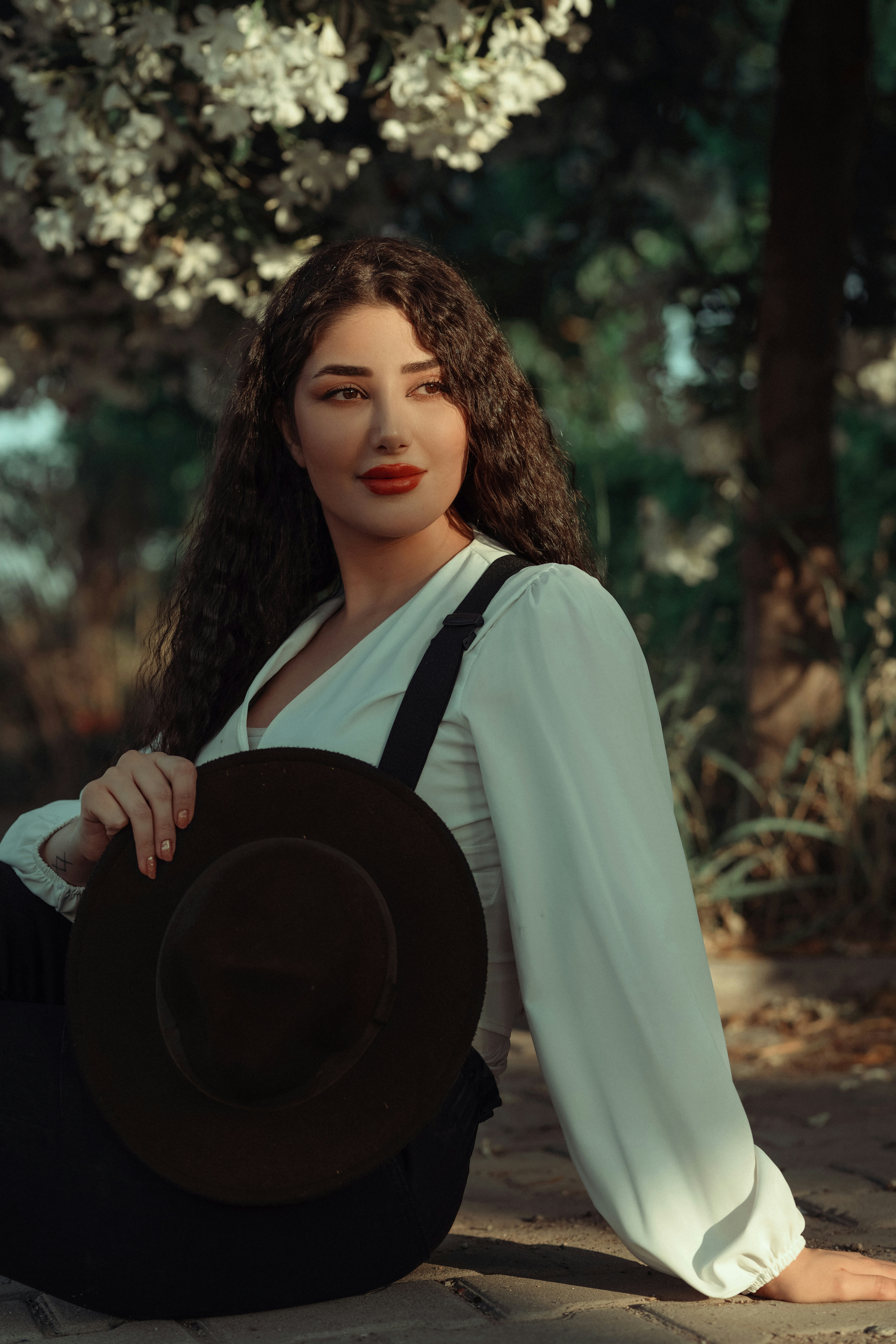 모자를 쓰고 땅에 앉아 있는 여자