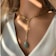 Close-up of a woman wearing a delicate gold necklace from aks jewellery, softly lit.