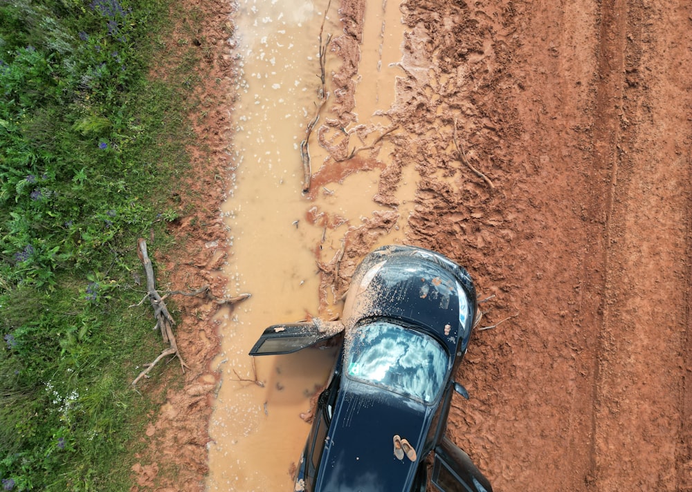 a car is stuck in the mud on a dirt road