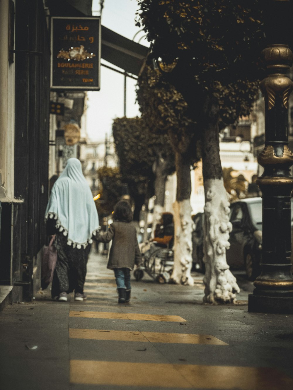 a woman and a child walking down a street