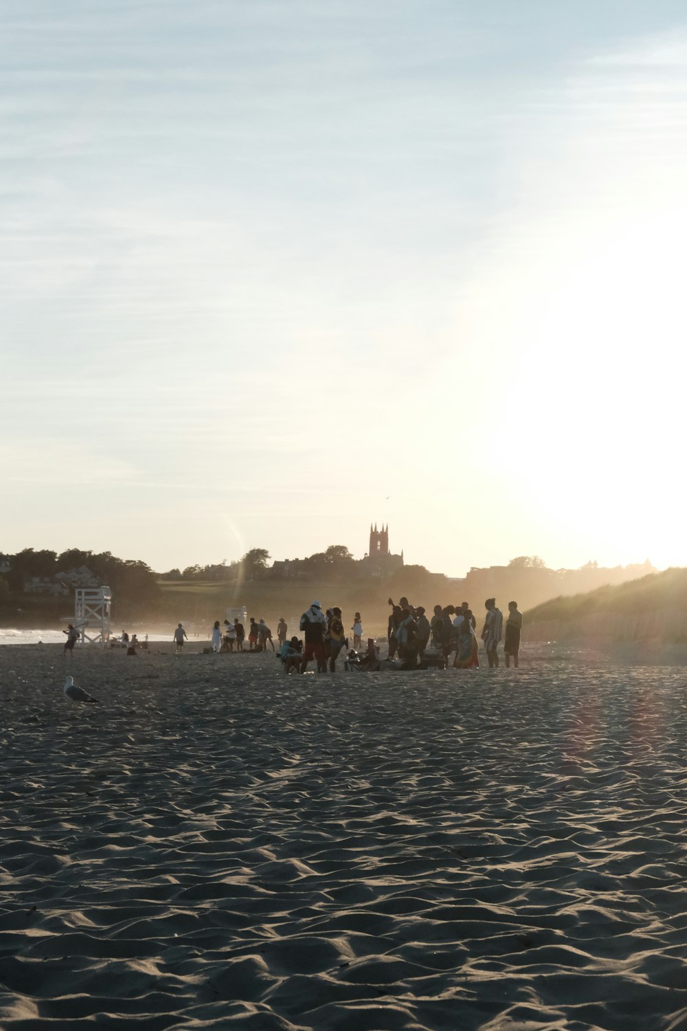 a group of people standing on top of a sandy beach