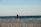 a man standing on top of a sandy beach next to the ocean
