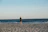 a man standing on top of a sandy beach next to the ocean