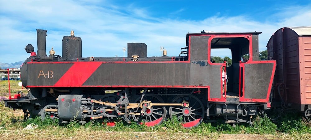 a red and black train engine sitting on the tracks