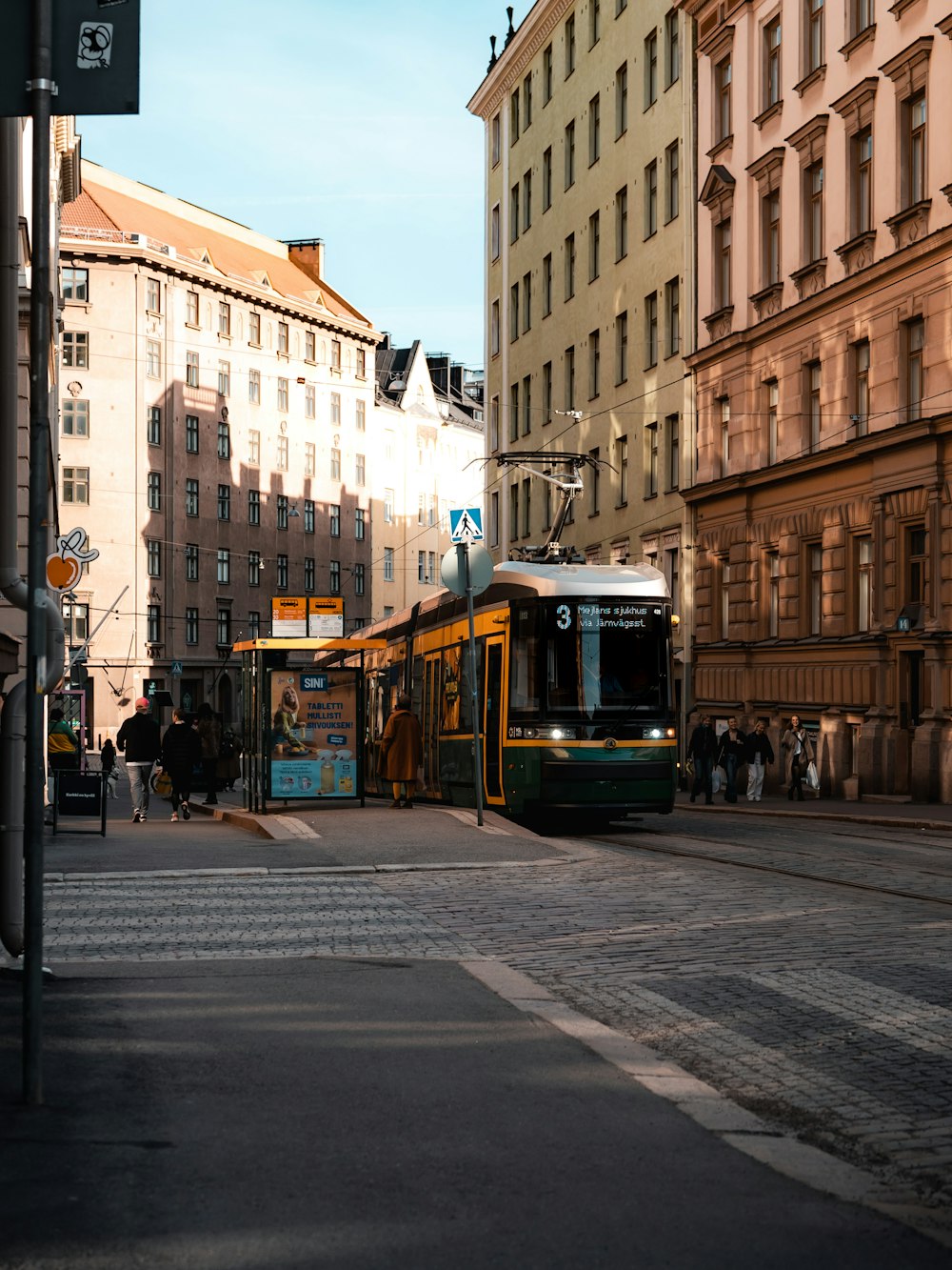 a train on a city street next to tall buildings