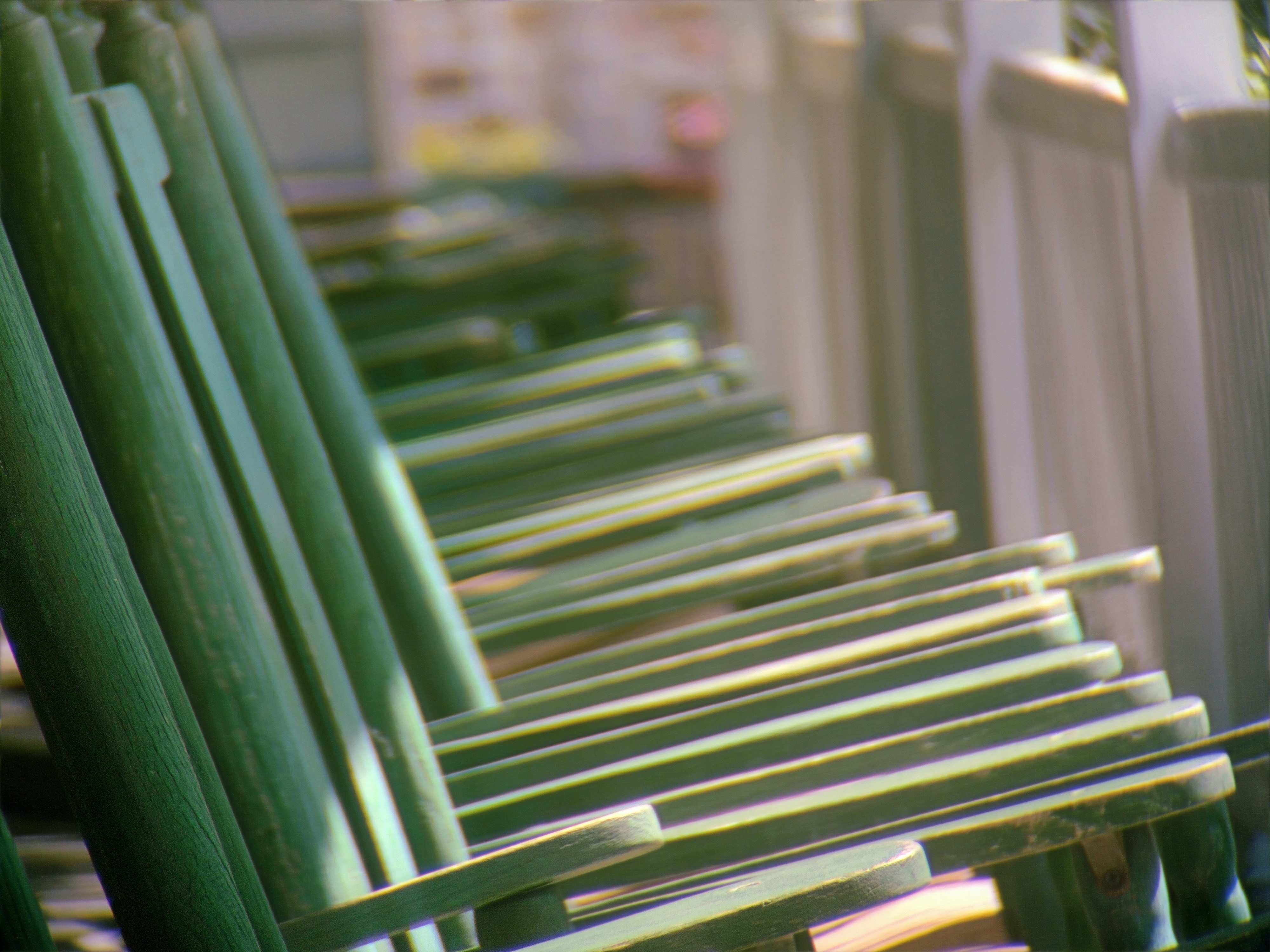 Industrial-green metal benches recede into a soft, blurred background along a diagonal axis.