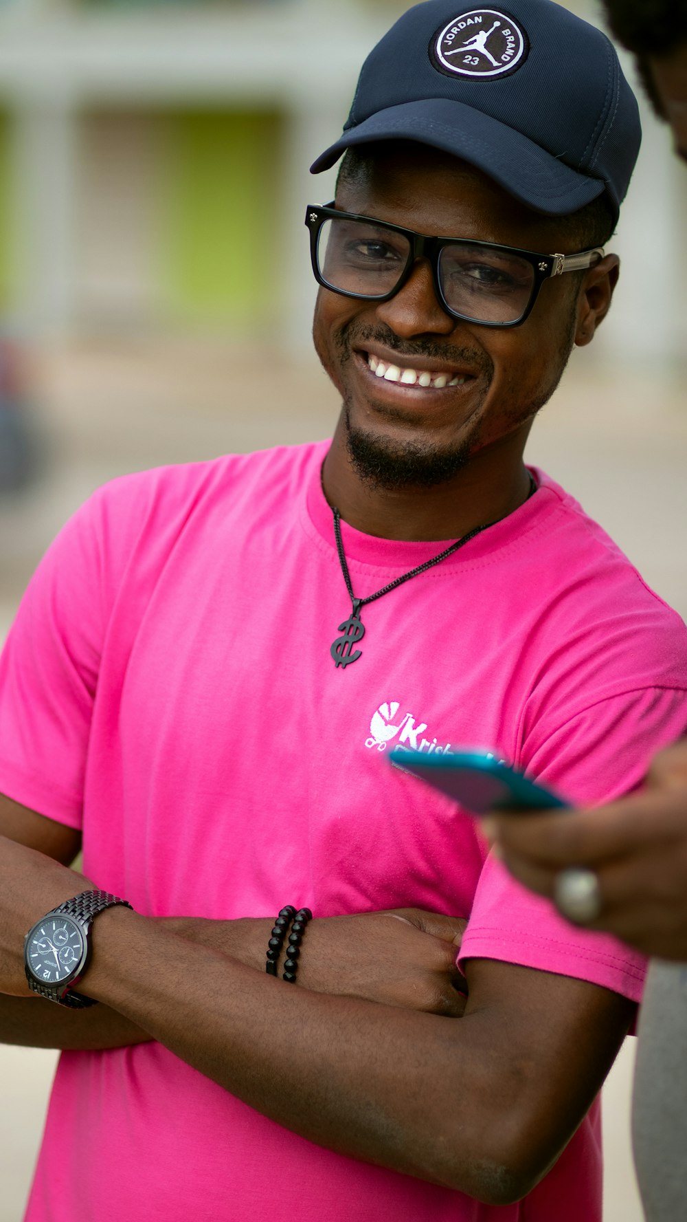 Un uomo con una camicia rosa e un cappello nero