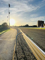 Sunset casting golden light over the empty circuit, hinting at the promise of future races.