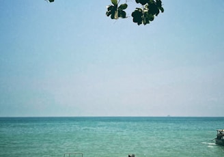 a boat sitting on top of a beach next to the ocean