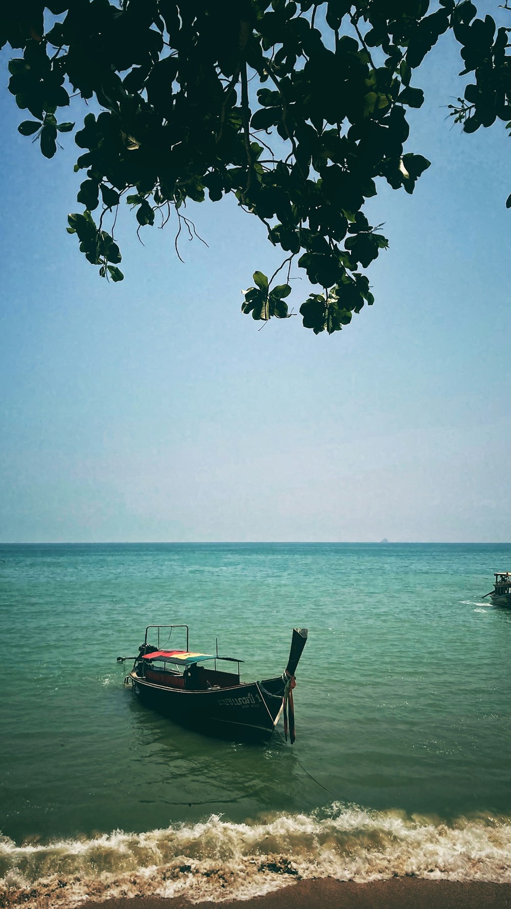 Un barco sentado en la cima de una playa junto al océano