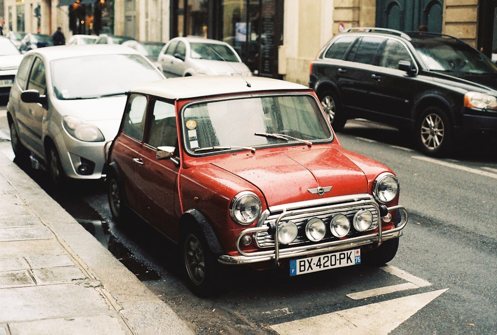 a small red car parked on the side of the road