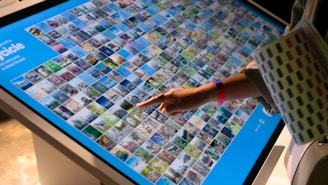 a person pointing at a large display of pictures
