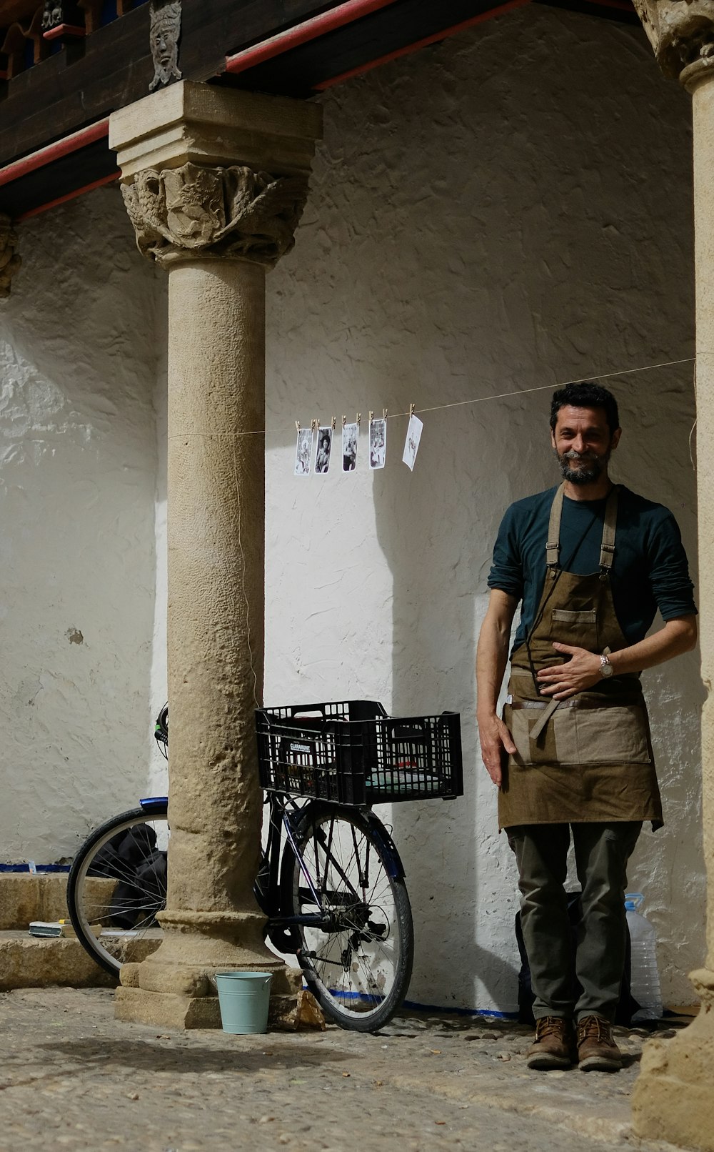 a man standing next to a bike in front of a building