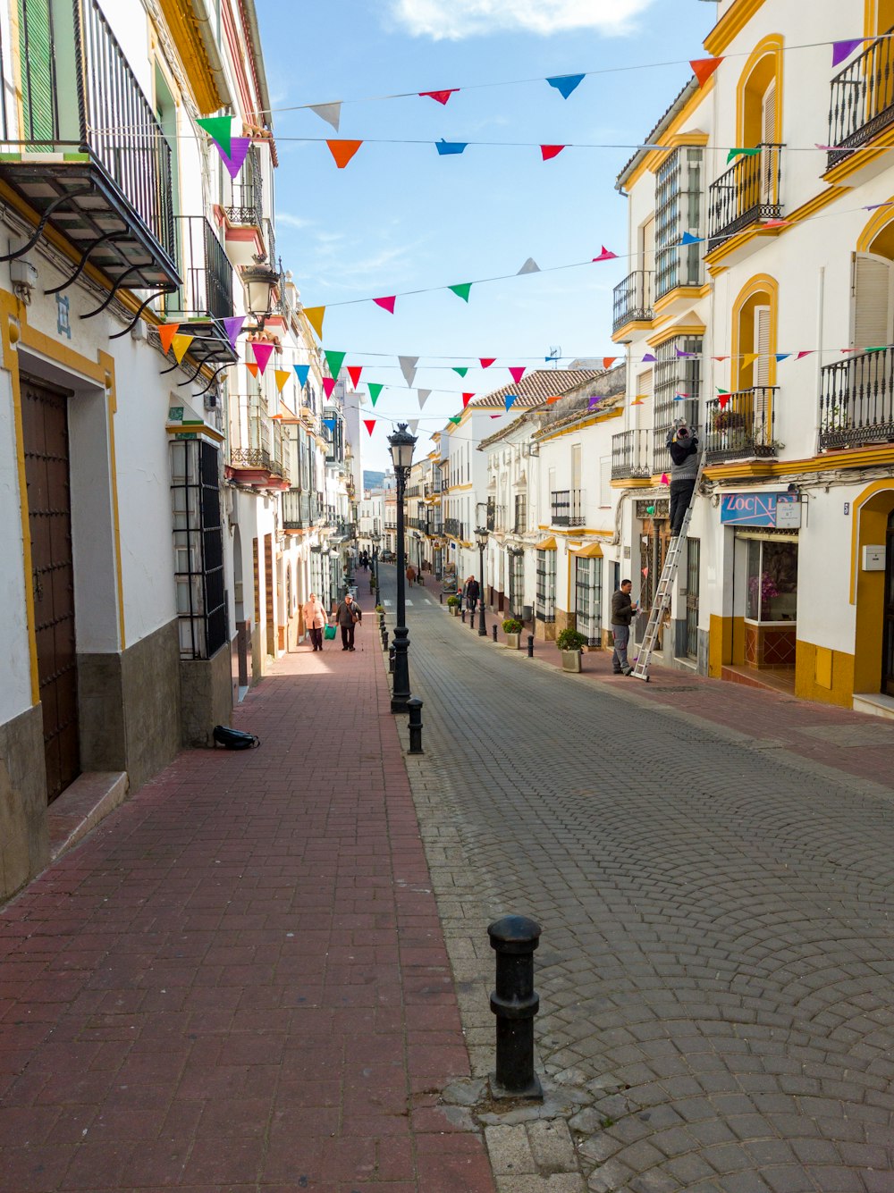 a street lined with buildings and colorful flags