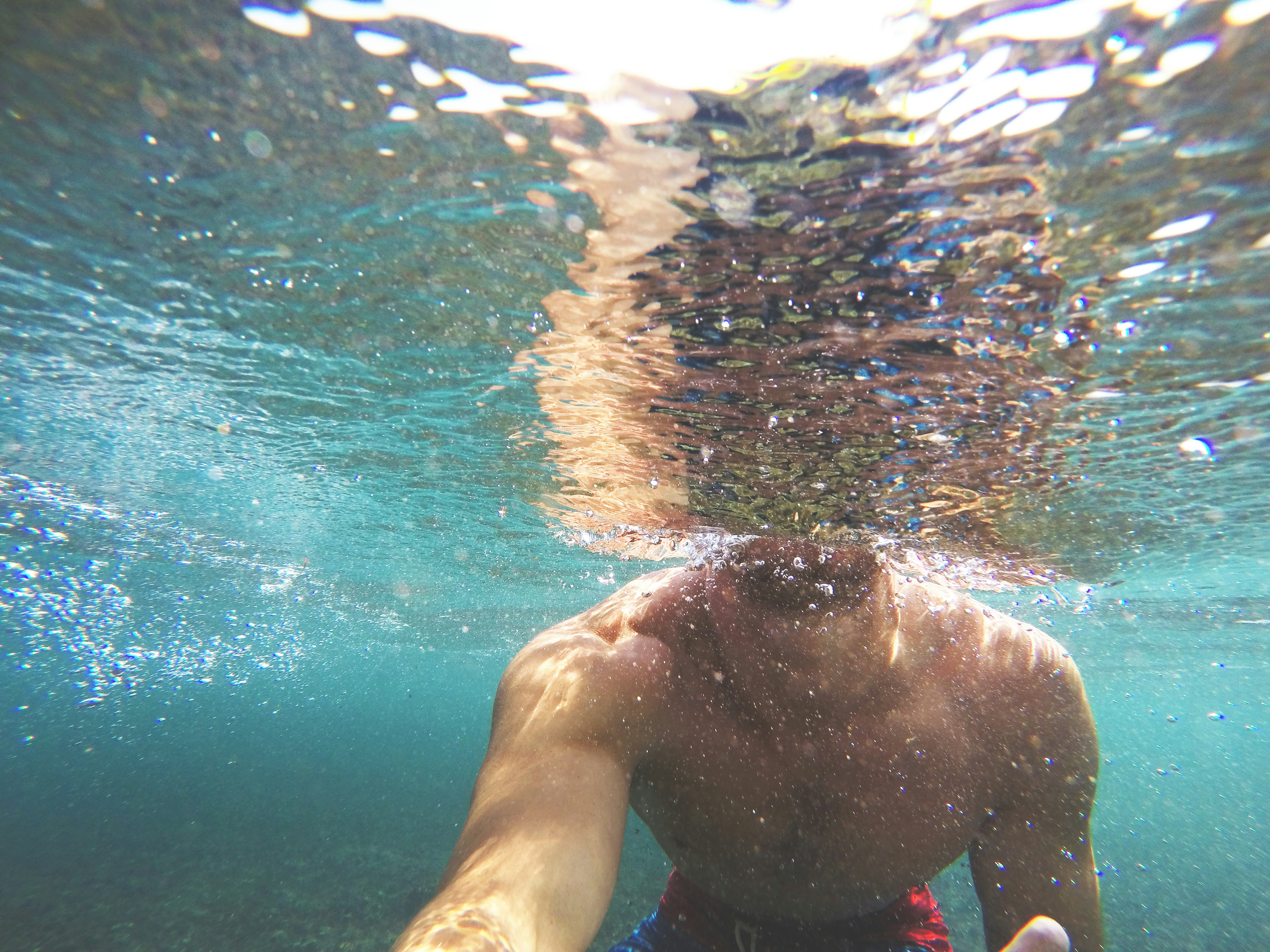 a man swimming under the water in the ocean