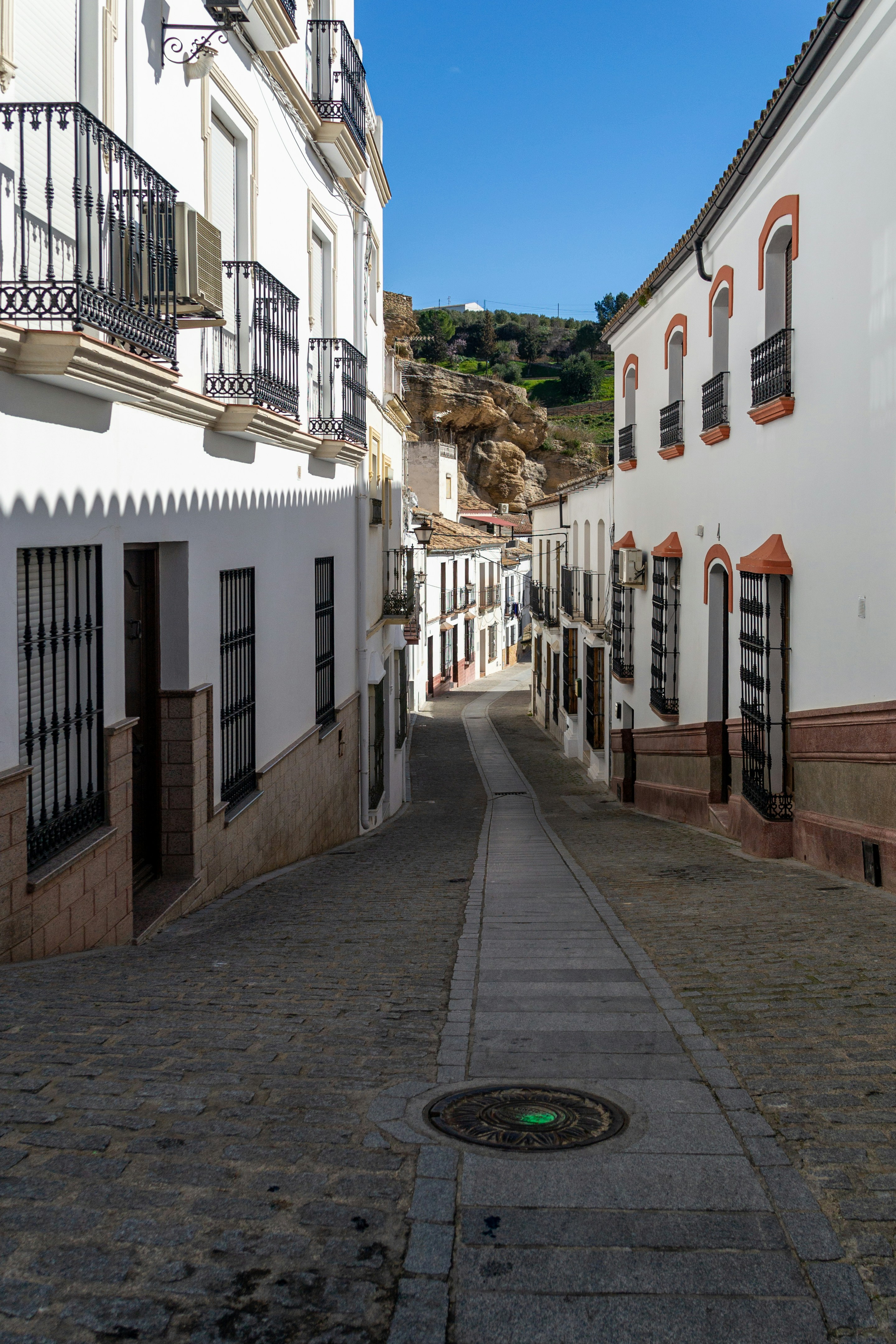 a narrow street with white buildings and balconies