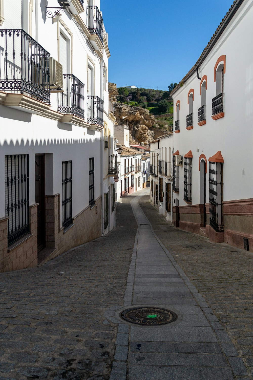 a narrow street with white buildings and balconies