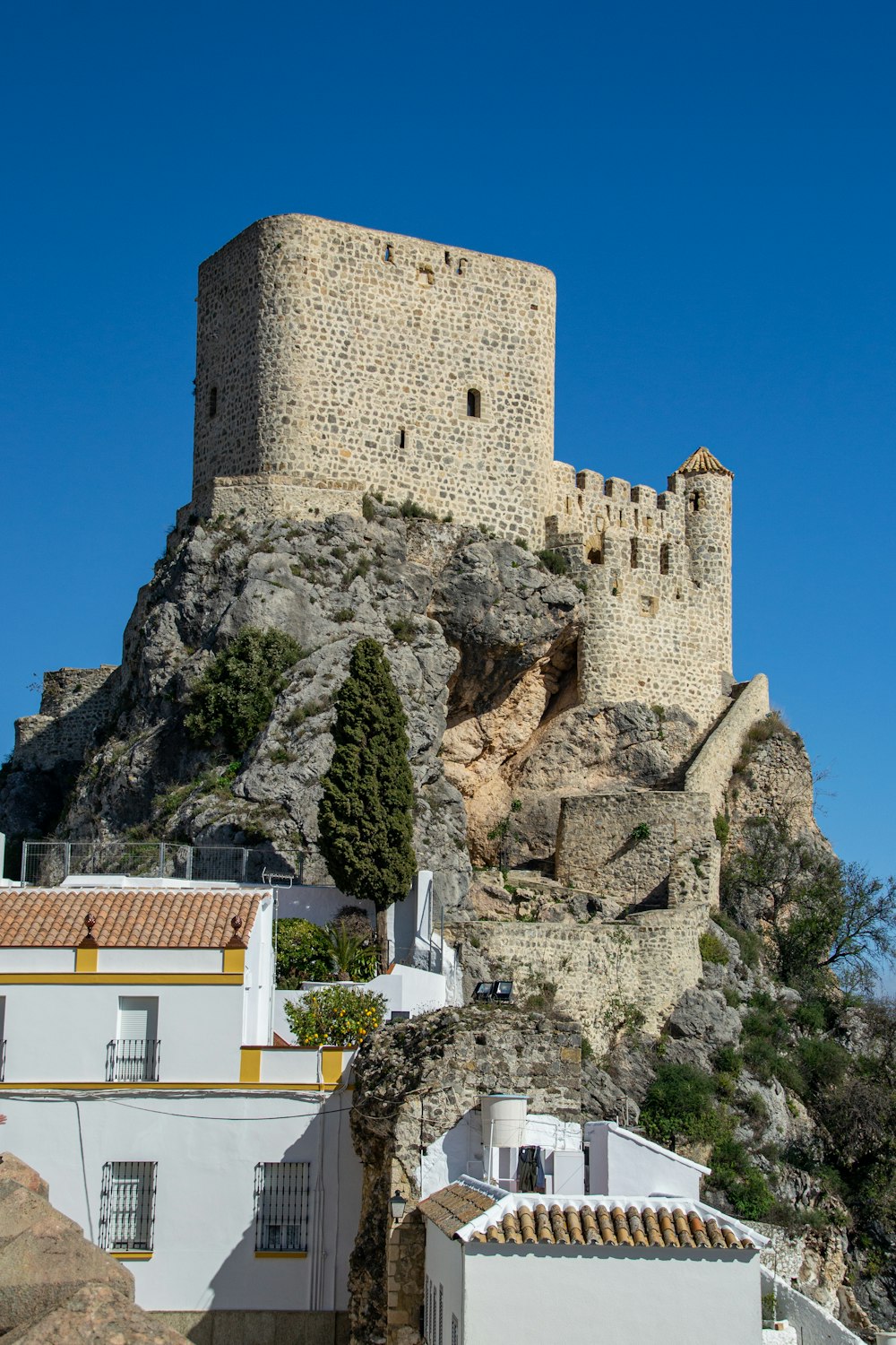 a castle on top of a hill with a blue sky in the background