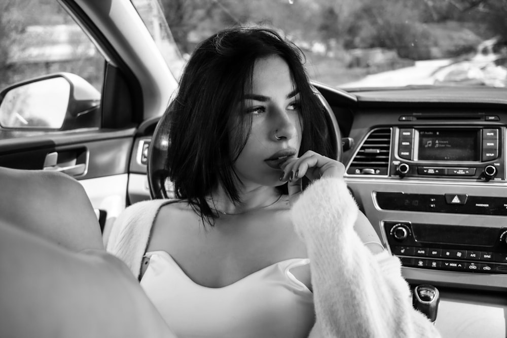 a woman sitting in the driver's seat of a car