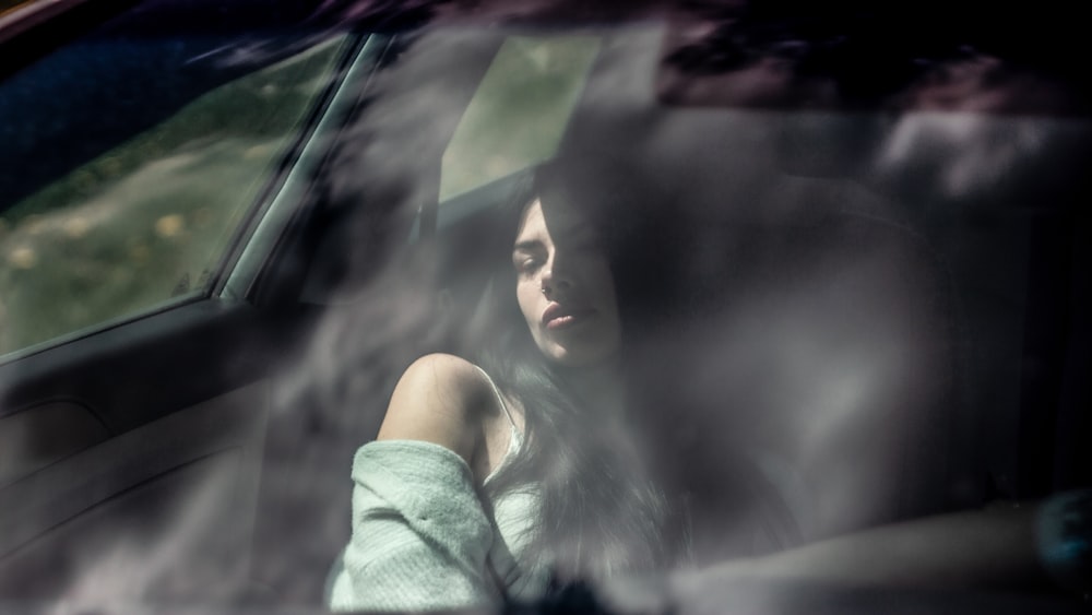 a woman sitting in the passenger seat of a car