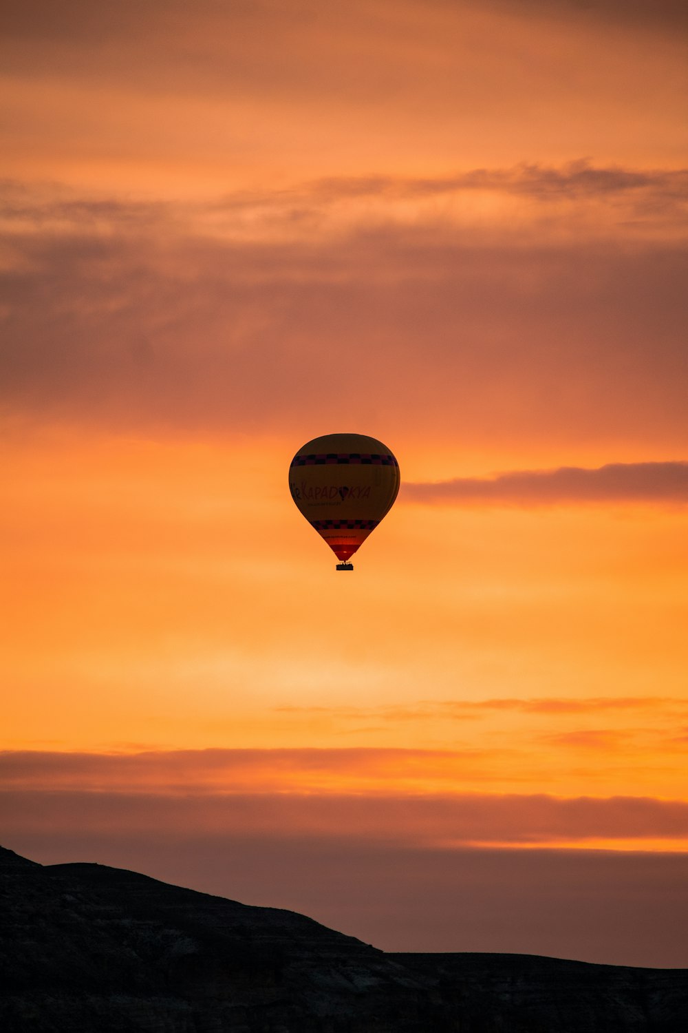 a hot air balloon flying in the sky at sunset