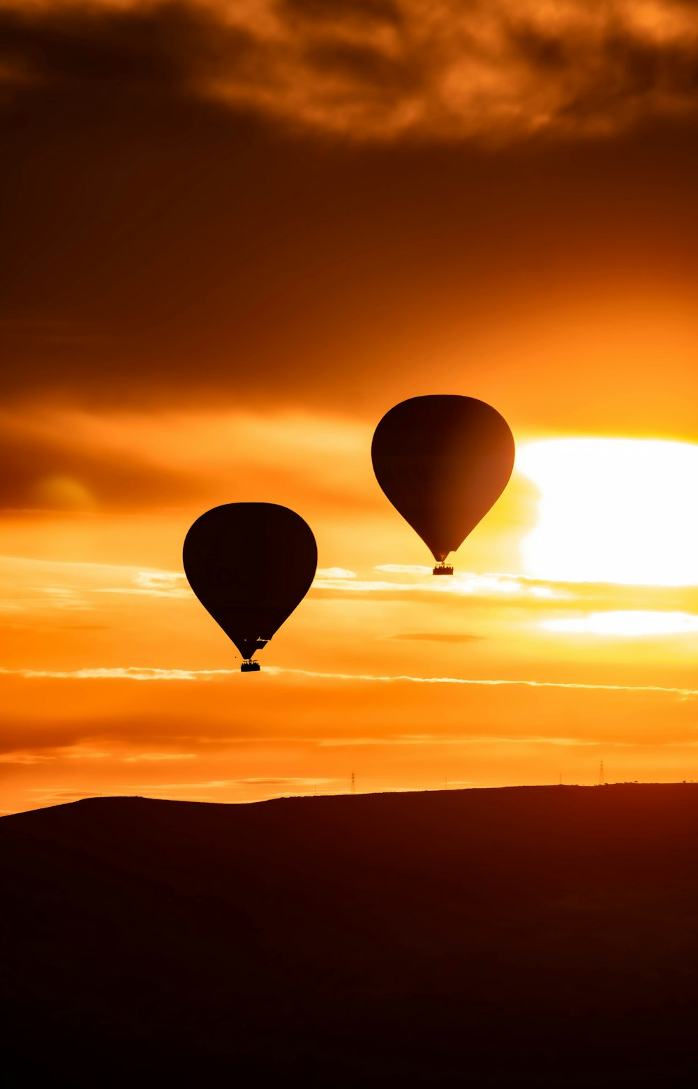 a couple of hot air balloons flying in the sky