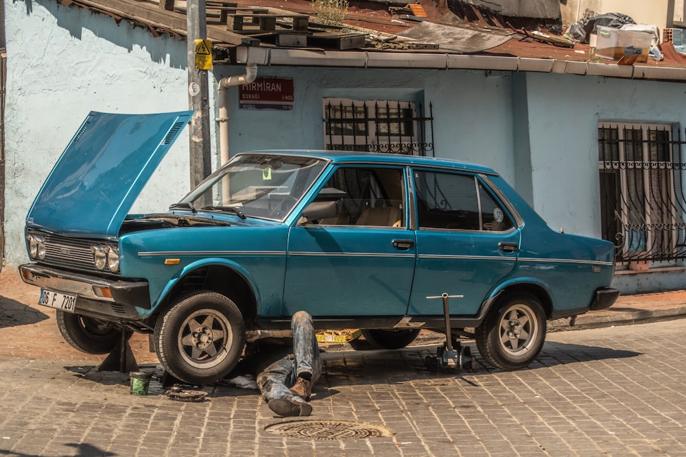 a blue car parked in front of a blue building