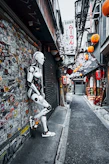 a robot standing next to a wall covered in stickers