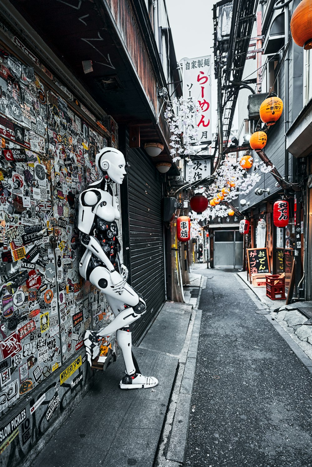 a robot standing next to a wall covered in stickers