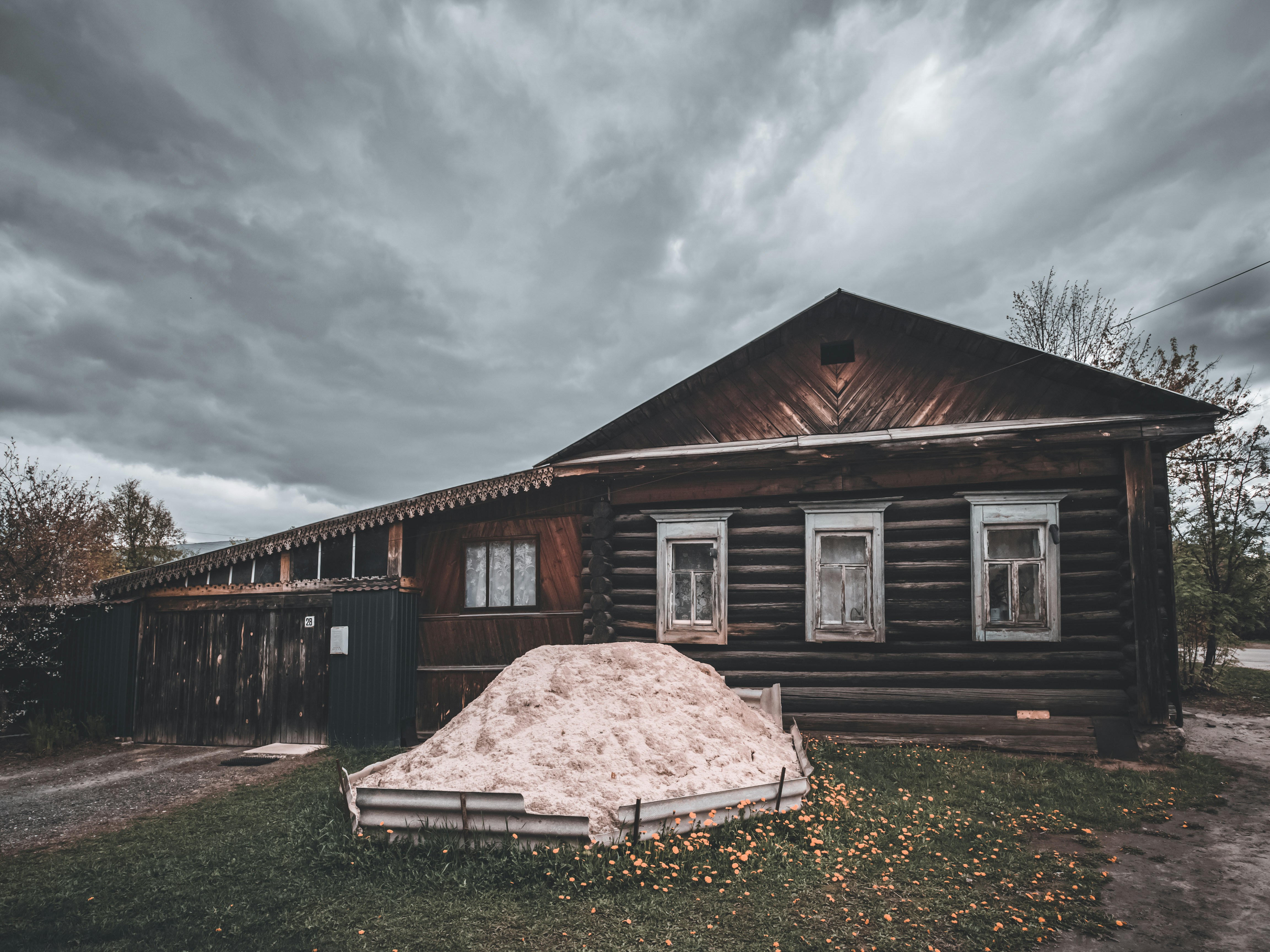 an old log cabin with a mattress in front of it