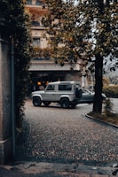 A family loading luggage into a roomy SUV in a European city street.