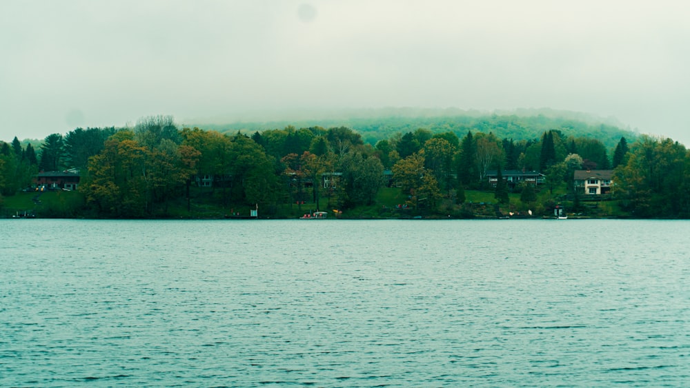 a large body of water with houses on a hill in the background