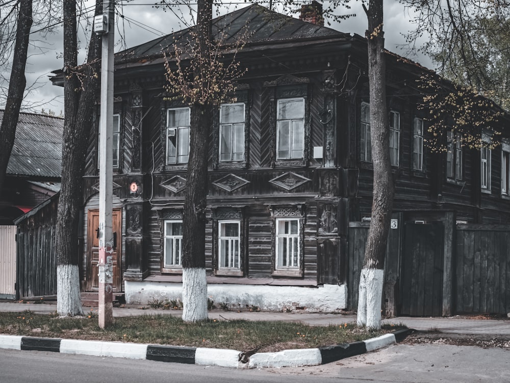 an old wooden house with trees in front of it