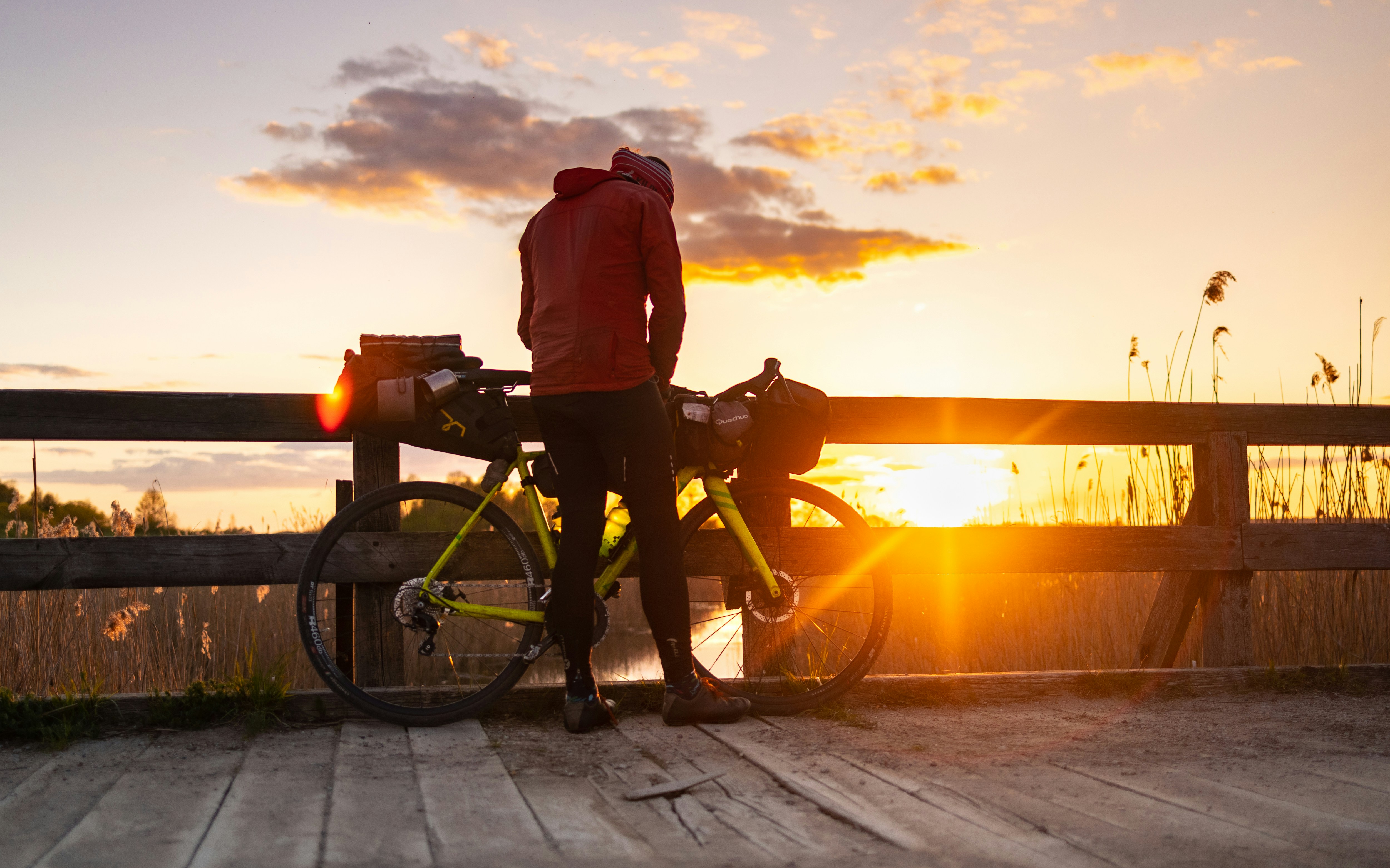 a person standing next to a bike on a bridge
