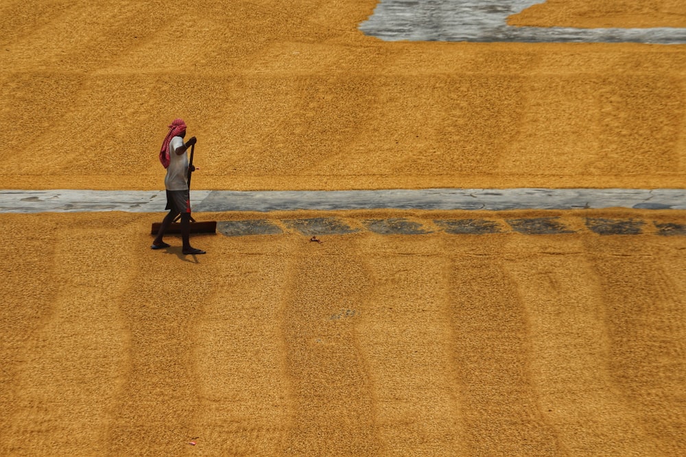 a person walking in a field with a red hat