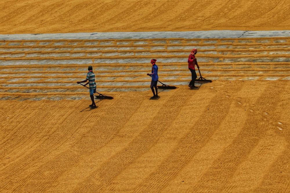 a group of people standing on top of a dirt field