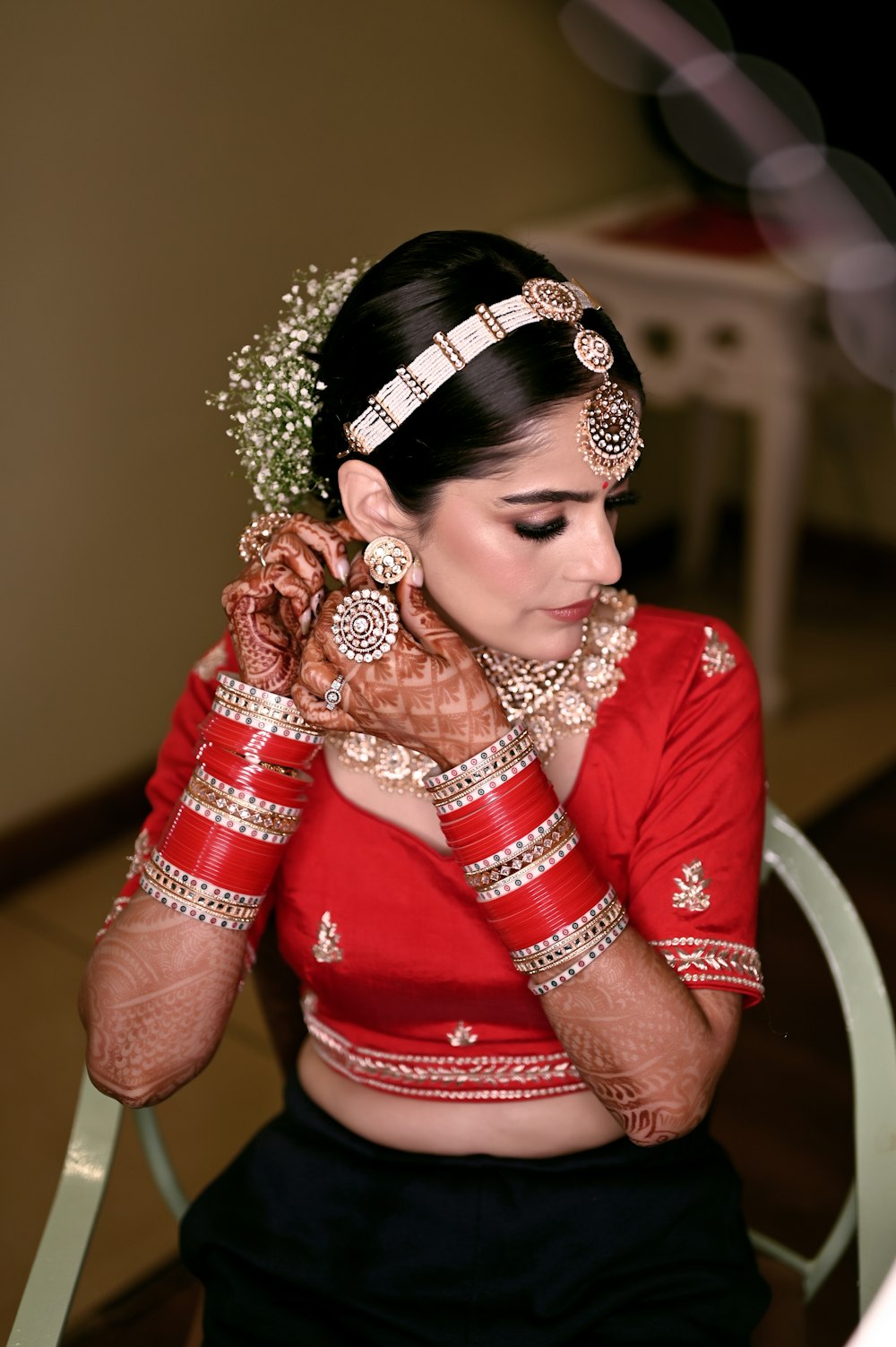 a woman in a red and black outfit is holding her hands to her face