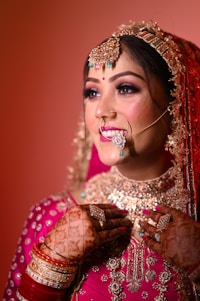 a woman in a red and gold bridal outfit