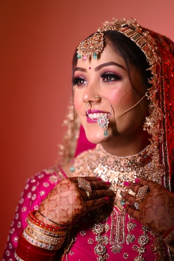 a woman in a red and gold bridal outfit