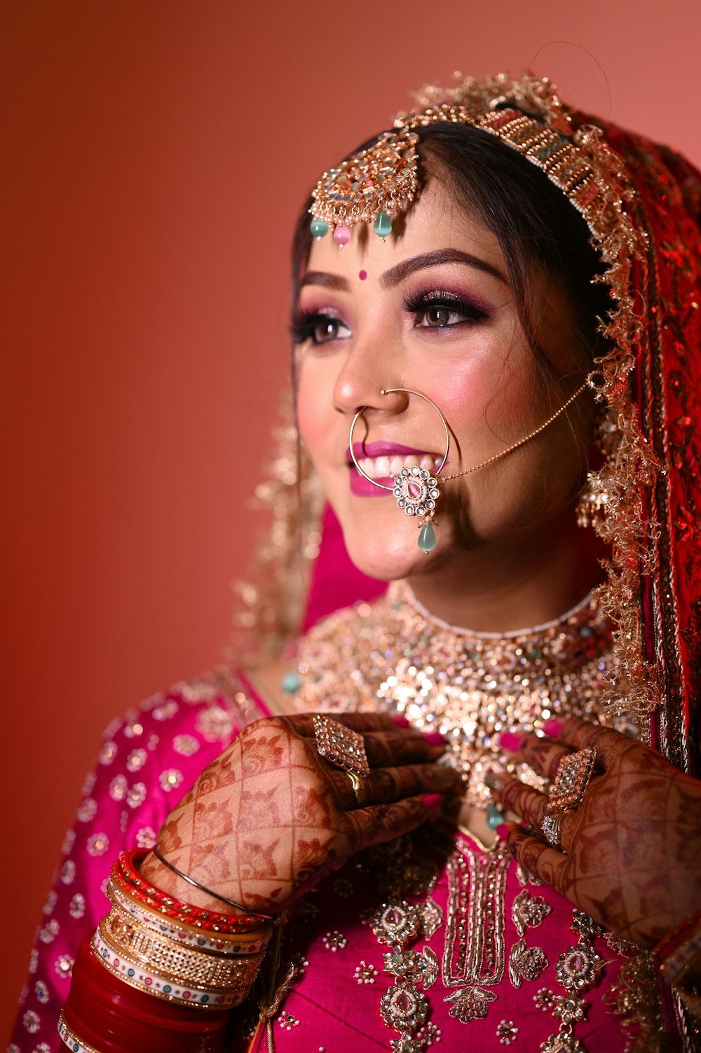 a woman in a red and gold bridal outfit