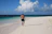 Happy man walking along the beach with a relaxed, confident smile.